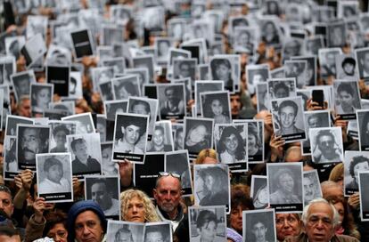 Cientos de personas levantan las fotografías de las 85 víctimas del atentado contra la mutua AMIA en 1994, durante una concentración en la sede de la Asociación de Mutuales Israelitas Argentinas (AMIA), en el barrio porteño de Once, en Buenos Aires (Argentina).