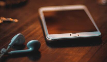 iPhone en un mesa con cascos