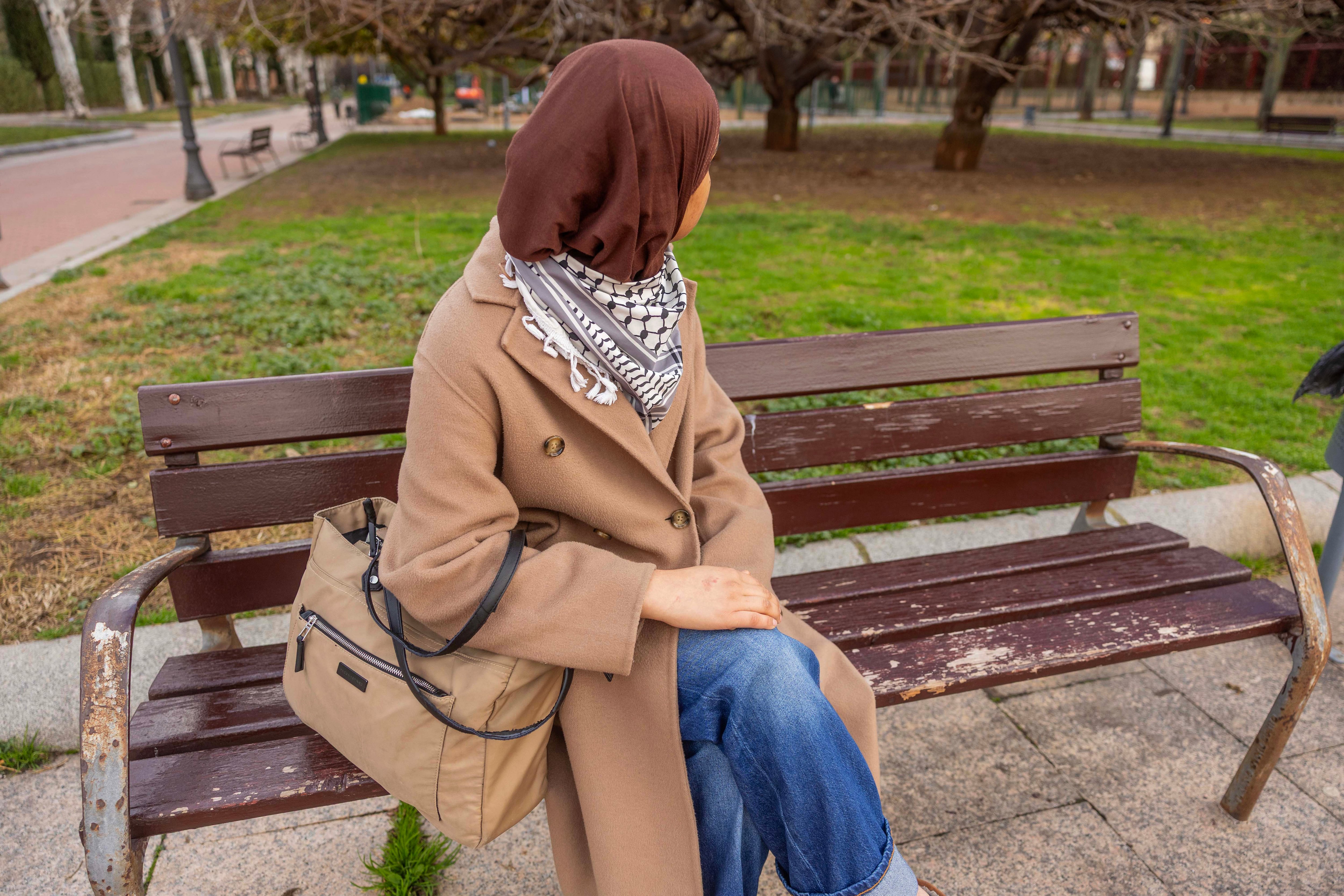 Eman Akram, de espaldas, en enero de 2026, en un banco de un parque del centro de Logroño.