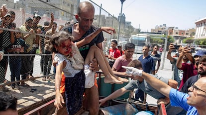 Un hombre llega al hospital Al Nasser, en Jan Yunis, con una niña herida en un ataque israelí en Gaza, el pasado lunes.  