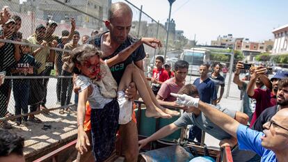 Un hombre llega al hospital Al Nasser, en Jan Yunis, con una niña herida en un ataque israelí en Gaza, el pasado lunes.