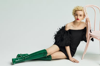 Julia Garner luce vestido de VALENTINO y botas de charol de MIU MIU.