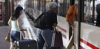 Varias personas montan a un tren en la estación de Chamartín, en Madrid.