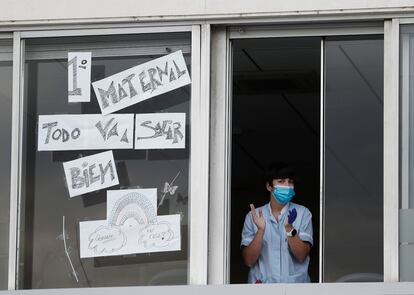Una enfermera sale a la ventana de una de las habitaciones del Hospital Virgen del Camino de Pamplona para participar también en el aplauso hacia sus compañeros