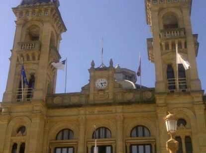 Fachada del Ayuntamiento de San Sebastián con la bandera española, enrollada, sobre el reloj.