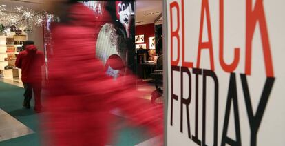 Un hombre pasa ante un cartel publicitario que hace alusión al 'Black Friday'.