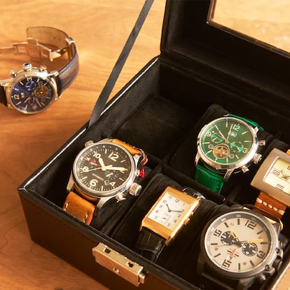 Caja organizadora de relojes sobre una mesa de madera.