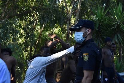 Um policial vigia o grupo de subsaarianos que conseguiu pular a cerca.