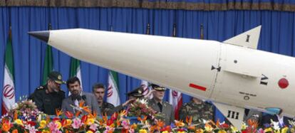 El presidente de Irán, Mahmud Ahmadineyad, escucha a su ministro de Defensa, general Vahidi, durante el desfile del Día de las Fuerzas Armadas.