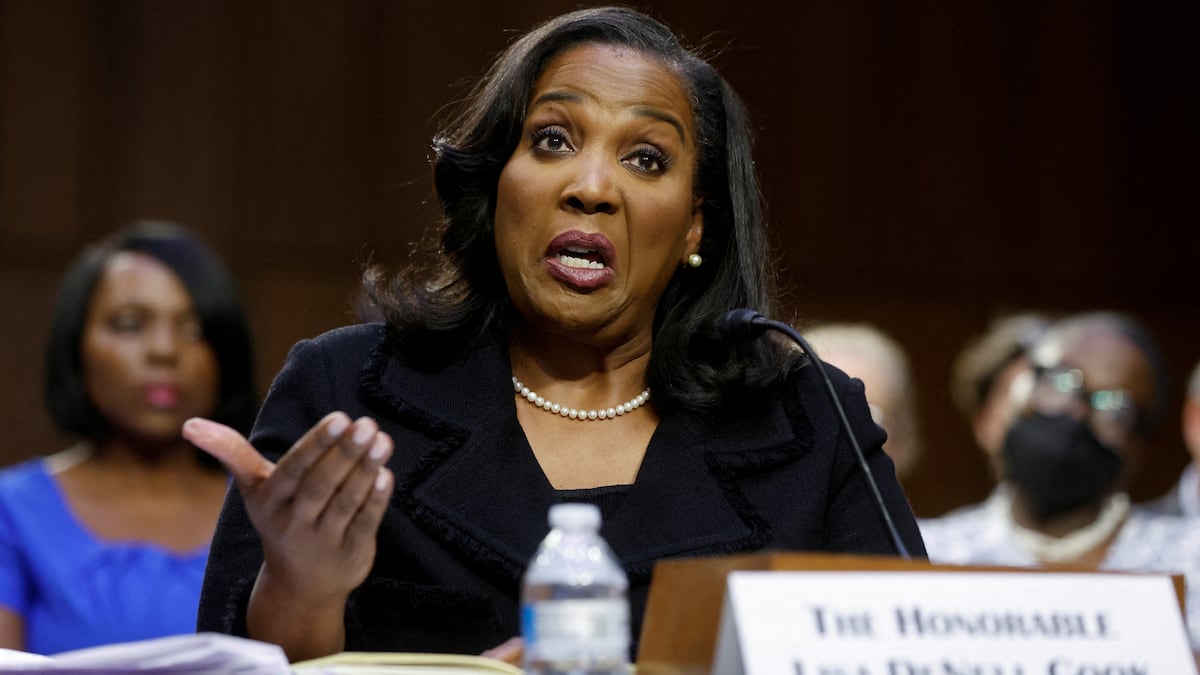 Fotografía de alta calidad de Lisa Cook testificando en el Senado de Estados Unidos en junio de 2023, con un enfoque en su expresión seria y profesional, capturando la solemnidad de su nominación como gobernadora de la Fed. Estilo documental y realista.