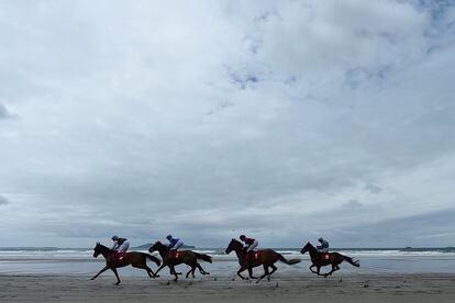 Jinetes compiten durante un carrera en la playa de Carrowniskey, en Irlanda.