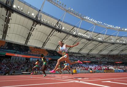 Marie-Josee Ta Lou (al fondo), de Costa de Marfil, cruza la línea de meta en primer lugar durante la disciplina de 100m femenino, el 20 de agosto.