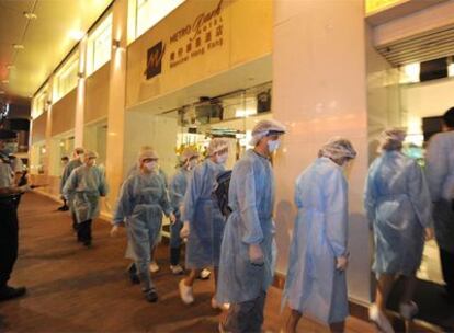 Los trabajadores sanitarios acceden al hotel sellado en Hong Kong con 300 personas dentro.
