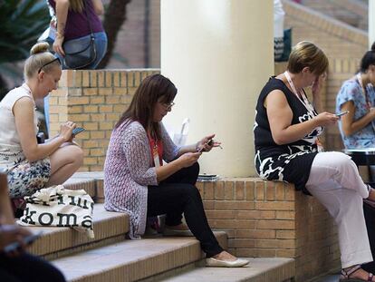 Mujeres participantes en el congreso EAIE 2017 usan el móvil.