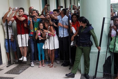 People wait to catch a glimpse of models and celebrities who are in town to attend a fashion show by Chanel, the first major fashion house to send models down the catwalk in Cuba, in Havana