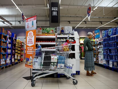 A customer shops next to a sign reading 'Anti-inflation challenge, third price cut' at a Carrefour supermarket in Montesson near Paris, France, September 13, 2023.