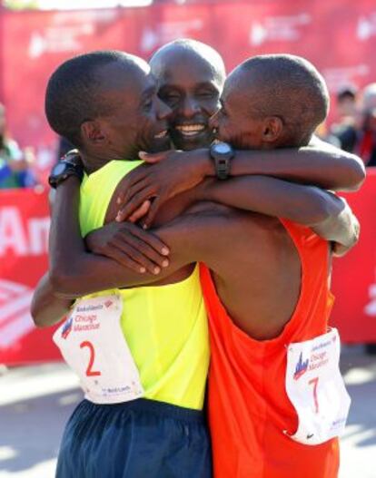 Los kenianos Kipchoge, Kittwara y Chumba se abrazan tras cruzar la meta del maratón de Chicago.