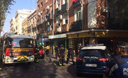 Agentes de bomberos tras sofocar las llamas en el edificio de Puente de Vallecas.