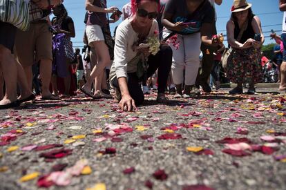 La gente recoge flores después del cortejo fúnebre.