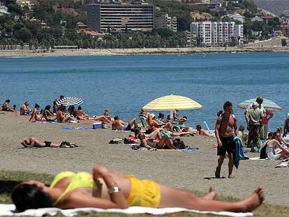 Turistas, ayer, en la playa de La Malagueta.