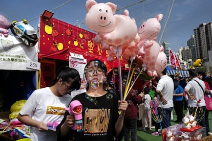 Vendedores tentam atrair os clientes para comprar balões de porquinhos em Hong Kong, na China, nesta terça-feira, quando é celebrado o Ano Novo Chinês.