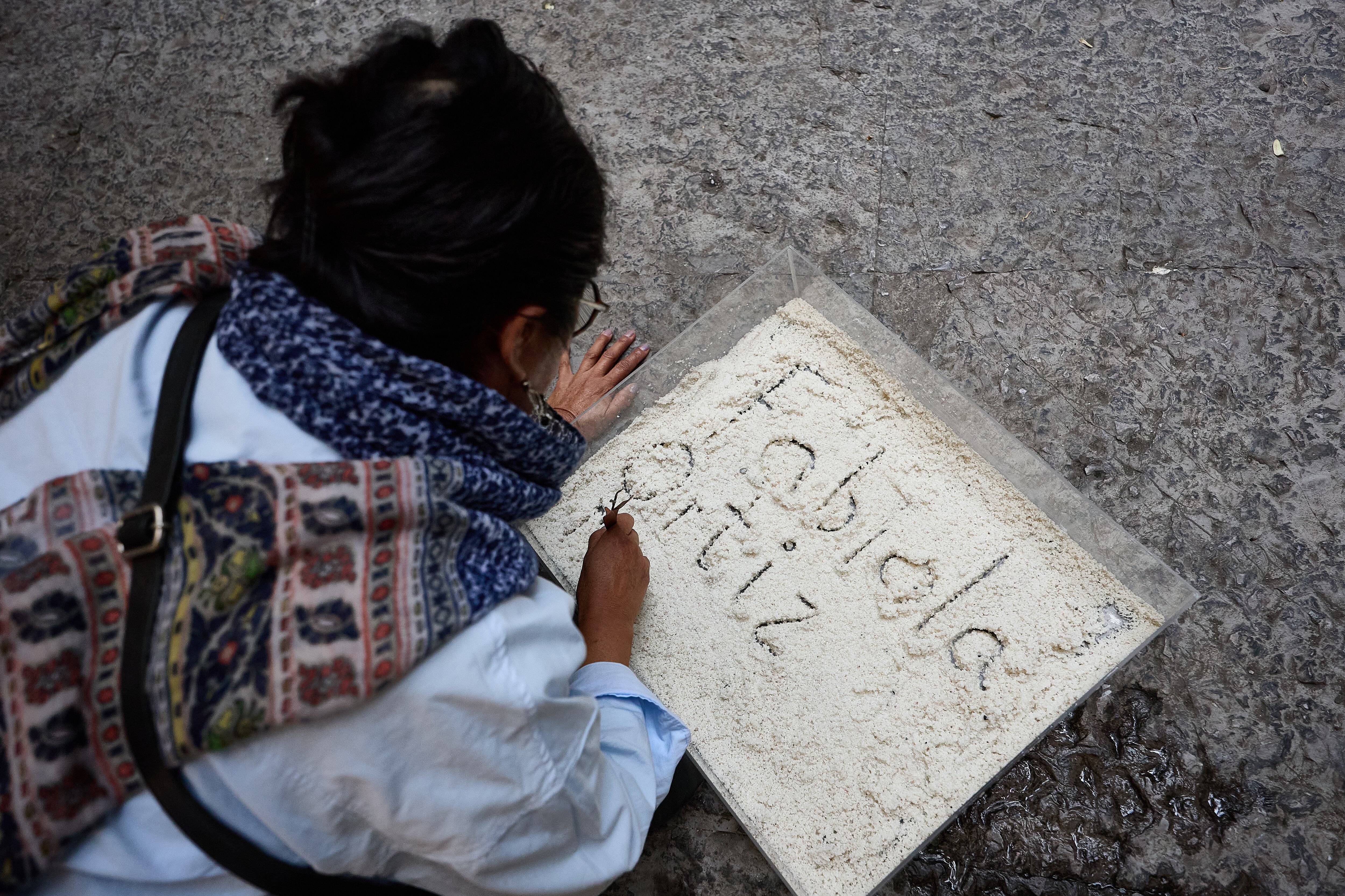 Sara Güizado, maestra jubilada, escribe el nombre de Fabiola Ortíz, una colega asesinada.