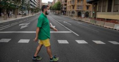 Un vecino cruza la calle en una avenida de Catalunya prácticamente vacía.