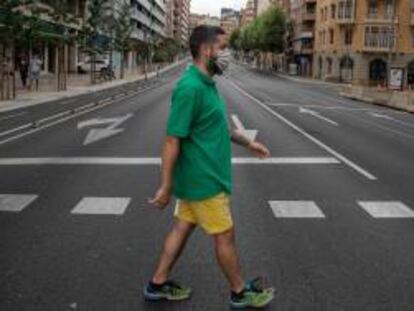 Un vecino cruza la calle en una avenida de Catalunya prácticamente vacía.