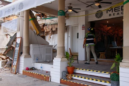 A National Police officer investigates outside the collapsed building on May 24.