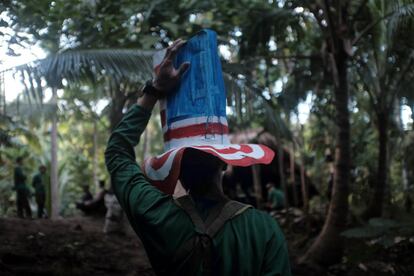 SIERRA MADRE - NOVEMBER 23, 2016: An NPA guerilla wears a hat mocking the United States after a program inside their camp on November 23, 2016 in Sierra Madre, Philippines. The New People's Army, the military organization of the communist movement in the Philippines, had warned of a possible failure of the ongoing peace talks with the Duterte government during a meeting with reporters on Wednesday, if the U.S. and Philippine treaty alliance continues. Tucked in the encampment of Sierra Madre mountains southeast of Manila, the Communist guerrillas have been waging a half century war against the U.S. treaty alliance with the Philippines, resisting against its military presence and trade freedom. The NPA also warned against making allies with countries like China and Russia who are also imperialists in nature, they said. (Photo by Jes Aznar/Getty Images)