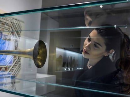 Una visitante de la exposici&oacute;n junto a una trompeta realizada a partir del instrumento original romano. 