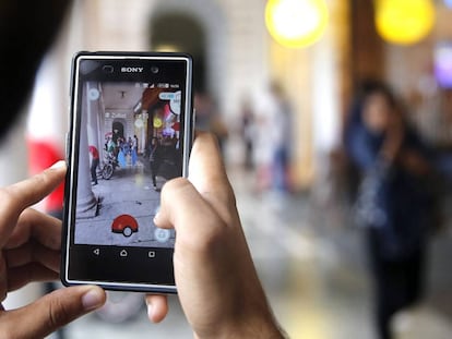 Un home intenta caçar un 'pokémon' després d'haver-lo localitzat.