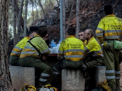 Los bomberos forestales descansan durante los trabajos de extinci&oacute;n del incendio de Gilet.