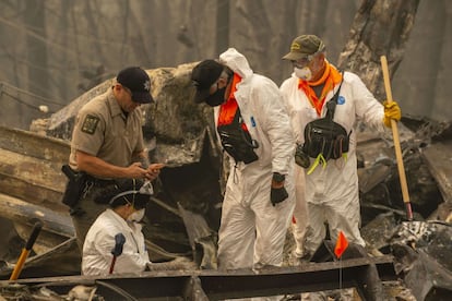 Personal de rescate buscan los posibles restos de un anciano desaparecido en un zona de casas móviles destruidas por el incendio forestal, en Ashland (Oregón), el viernes.