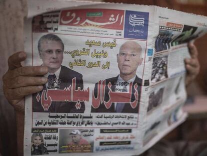 Un hombre lee un diario con la imagen de los dos candidatos que irán a la segunda vuelta de las presidenciales, Kaïs Saïd (derecha) y Nabil Karoui.