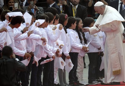 El papa Francisco (derecha) saluda a un grupo de niños a su llegada a la base aérea de Catam.