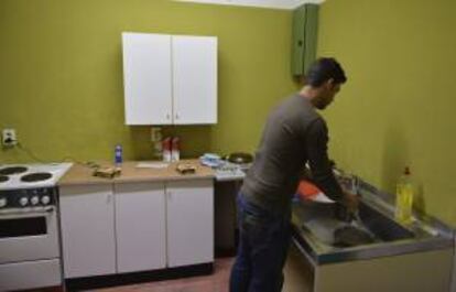 Abel, de 23 años, lava la cubertería en la "Alte Parteischule" de Erfurt, Alemania. Los 128 jóvenes se encuentran a la espera, desde hace meses, de iniciar el programa de formación profesional se encuentran "tristes" e "indignados", pero confían en una salida tras haberse iniciado la firma de los primeros contratos.