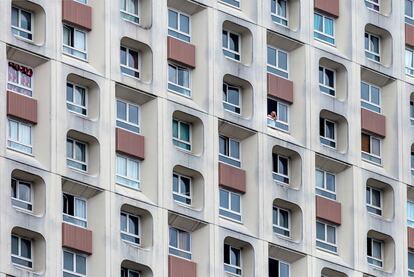 Un hombre mira por la ventana en un edificio de apartamentos de gran altura durante el segundo día de cierre ordenado por el gobierno francés para combatir el coronavirus el 18 de marzo de 2020 en París, Francia.
