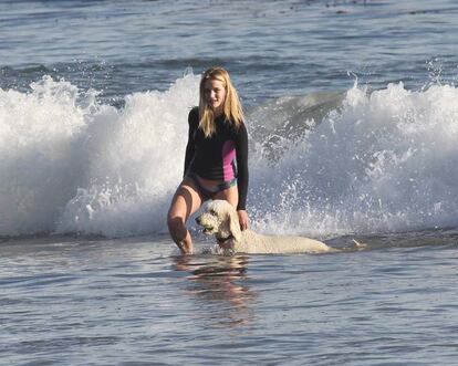 Rosie Huntington-Whiteley se divierte jugando con las olas junto a su inseparable perro.