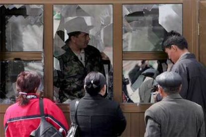 Ciudadanos de Kirguizistán se informan de la situación en su país en la sede del Gobierno en la capital, Bishkek.
