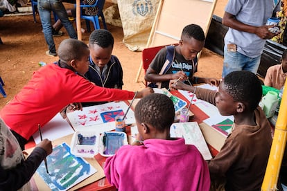 A group of children paints at the Art On stand, a project created by the Malawi Salim Sumaisi that uses art as a tool to combat the mental health challenges faced by young people in hospitals, prisons and refugee camps.