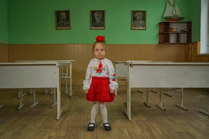 Lyuda posa el pasado mes de julio en una de las aulas que sobrevivió al bombardeo de la escuela de Horenka, Ucrania. Después de meses de guerra, muchos centros como este permanecerán cerrados este septiembre. El Gobierno considera que menos del 60% de las escuelas son seguras y están en condiciones de reabrir.