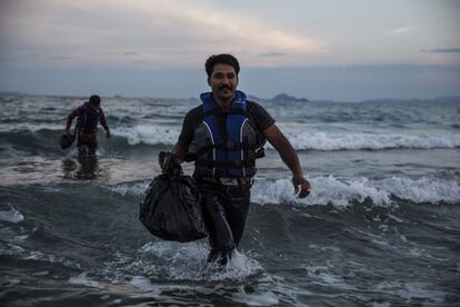 Imigrantes paquistaníes llegan en la playa al amanecer después de hacer su travesía de Turquía en Kos, Grecia.