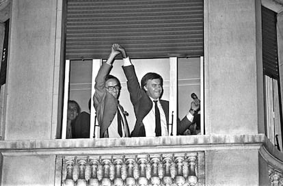 Alfonso Guerra (izquierda) levanta la mano de Felipe González, asomados ambos a una ventana del hotel Palace de Madrid, celebrando la histórica victoria del Partido Socialista Obrero Español (PSOE) en las elecciones legislativas.