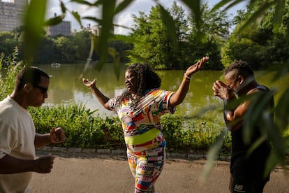 People dance and sing rumba on a sidewalk in Central Park.