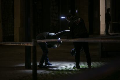 Agentes de investigacion criminal de los Mossos inspeccionan la escena del tiroteo.