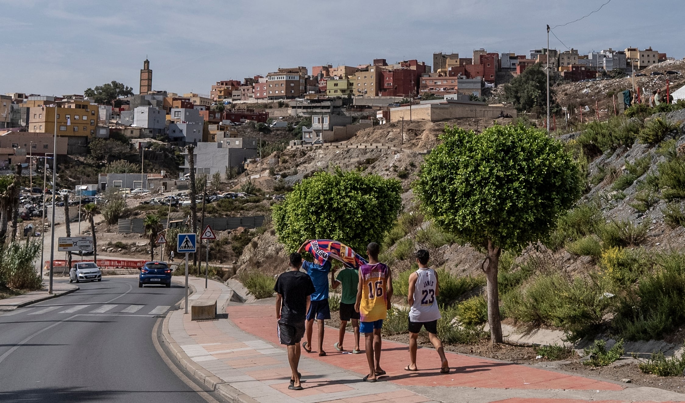 Los menores extranjeros no acompañados Adam, Zakarya, Ilyass, Younnes y un quinto amigo bajan de Loma Colmenar a El Tarajal, en Ceuta, este jueves.