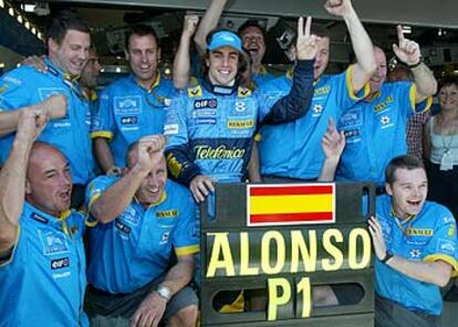 Alonso celebra su éxito con algunos componentes del equipo Renault.
