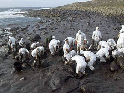 Un grupo de voluntarios recoge chapapote en los alrededores del cabo de Touriñán (A Coruña).