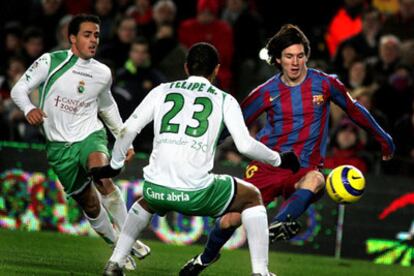 Messi, acosado por dos jugadores del Racing de Santander.